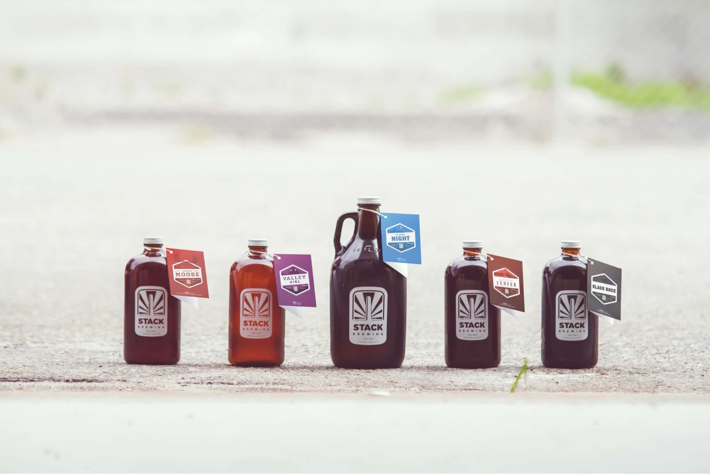 Lineup of Stack Brewing chubbies with branded tags