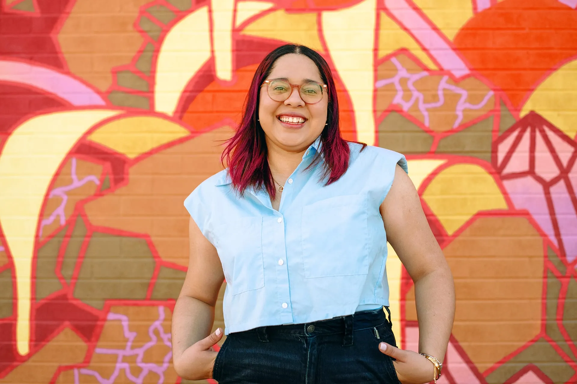 Anny Garcia of Studio123 standing in front of a colourful mural