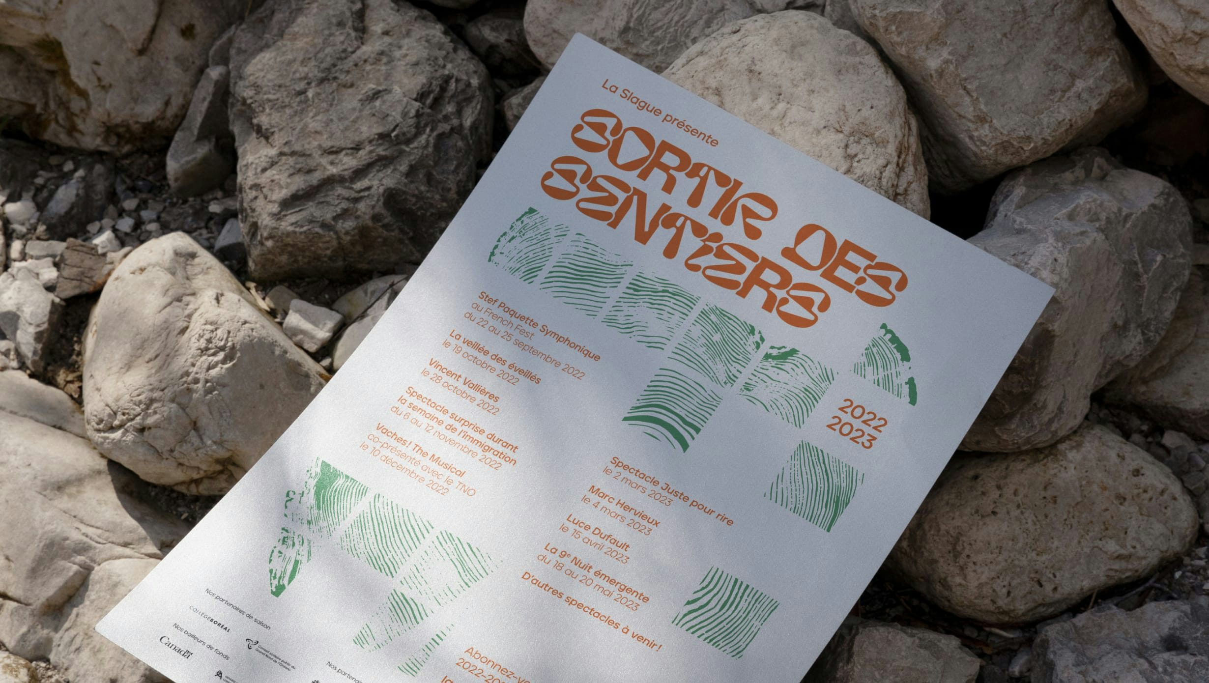 La Slague's 2021-2022 season poster placed on natural rock background
