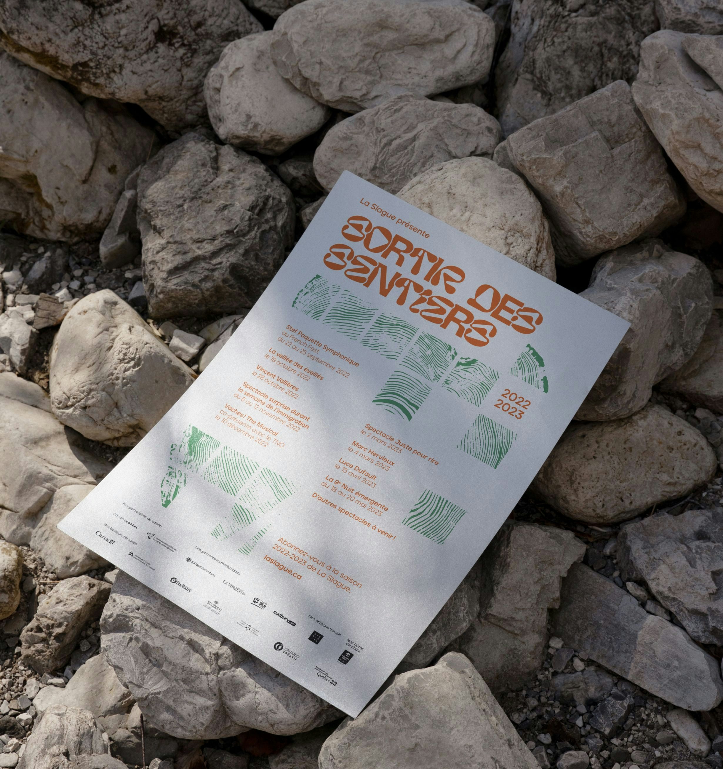 Branded 2021-2022 season poster for La Slague placed on rocks