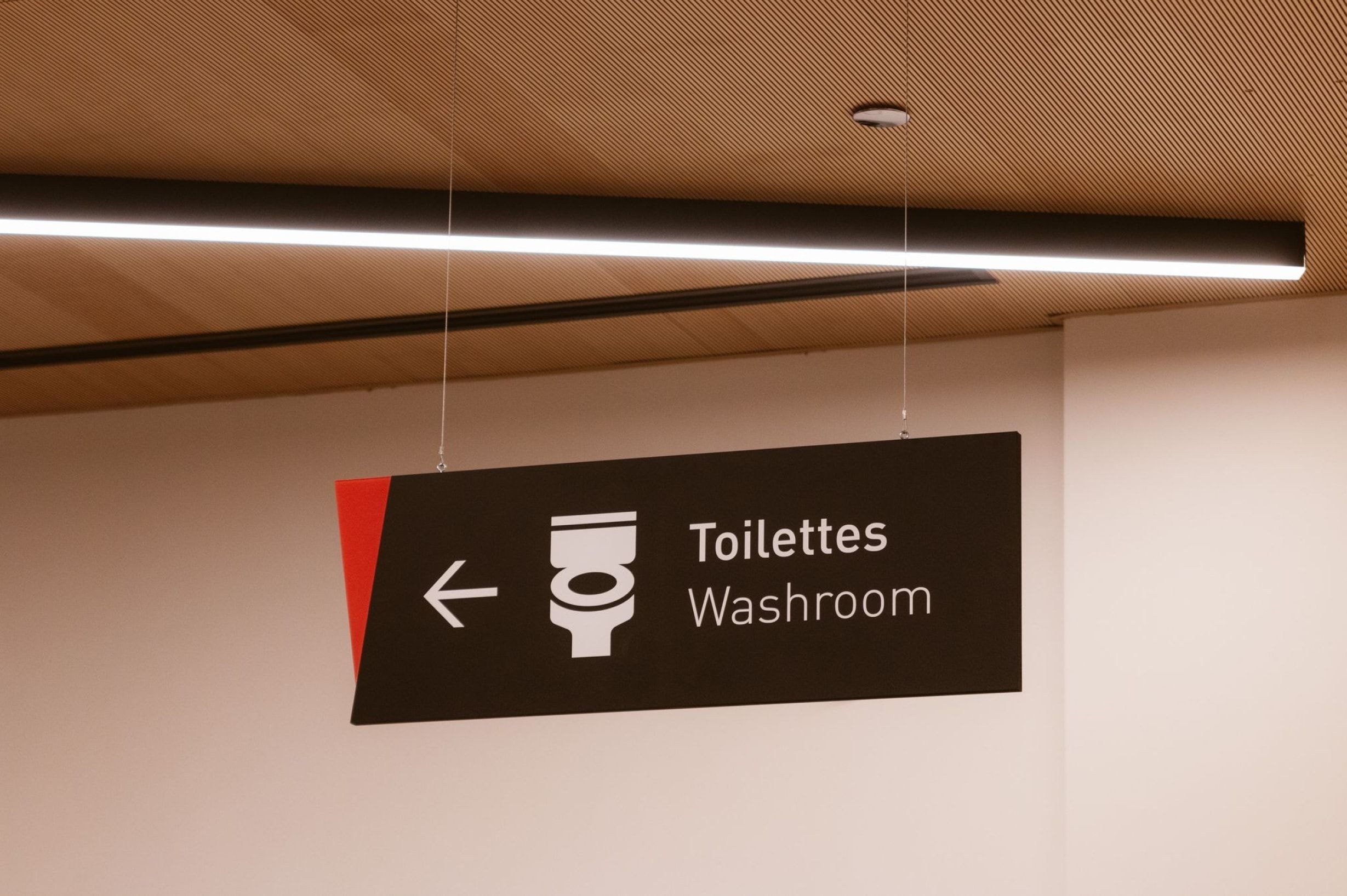 Suspended washroom sign at Place des Arts