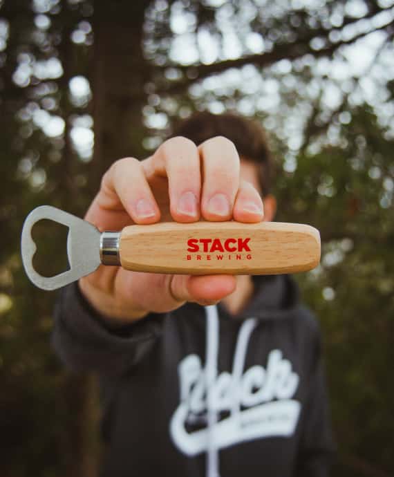 Man holding a Stack Brewing branded bottle opener