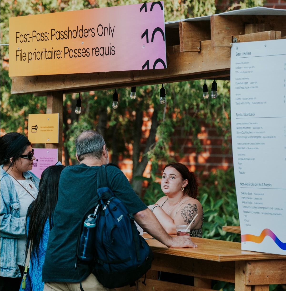 Patrons at pop-up bar being served by female server.